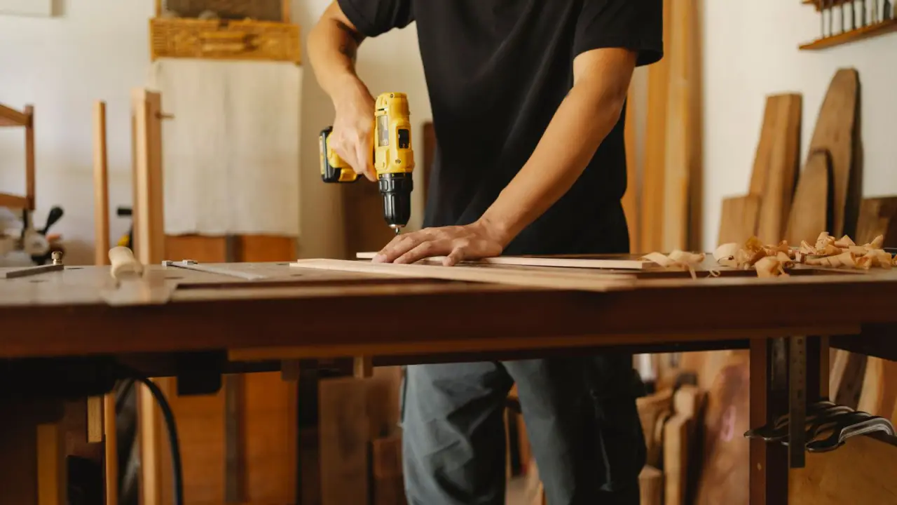 Menuisier travaillant une piece de bois dans son atelier