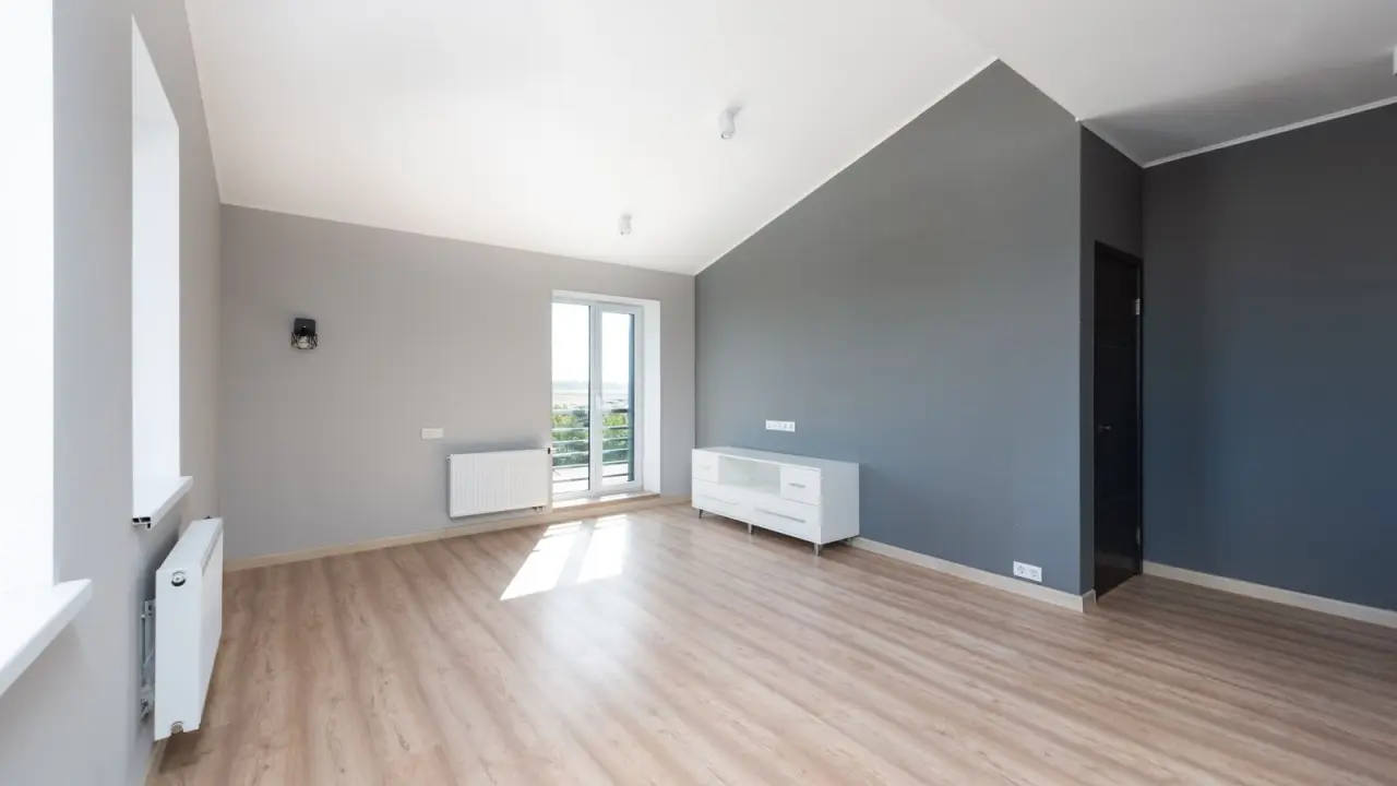Piece renovee en gris et blanc avec sol stratifie clair